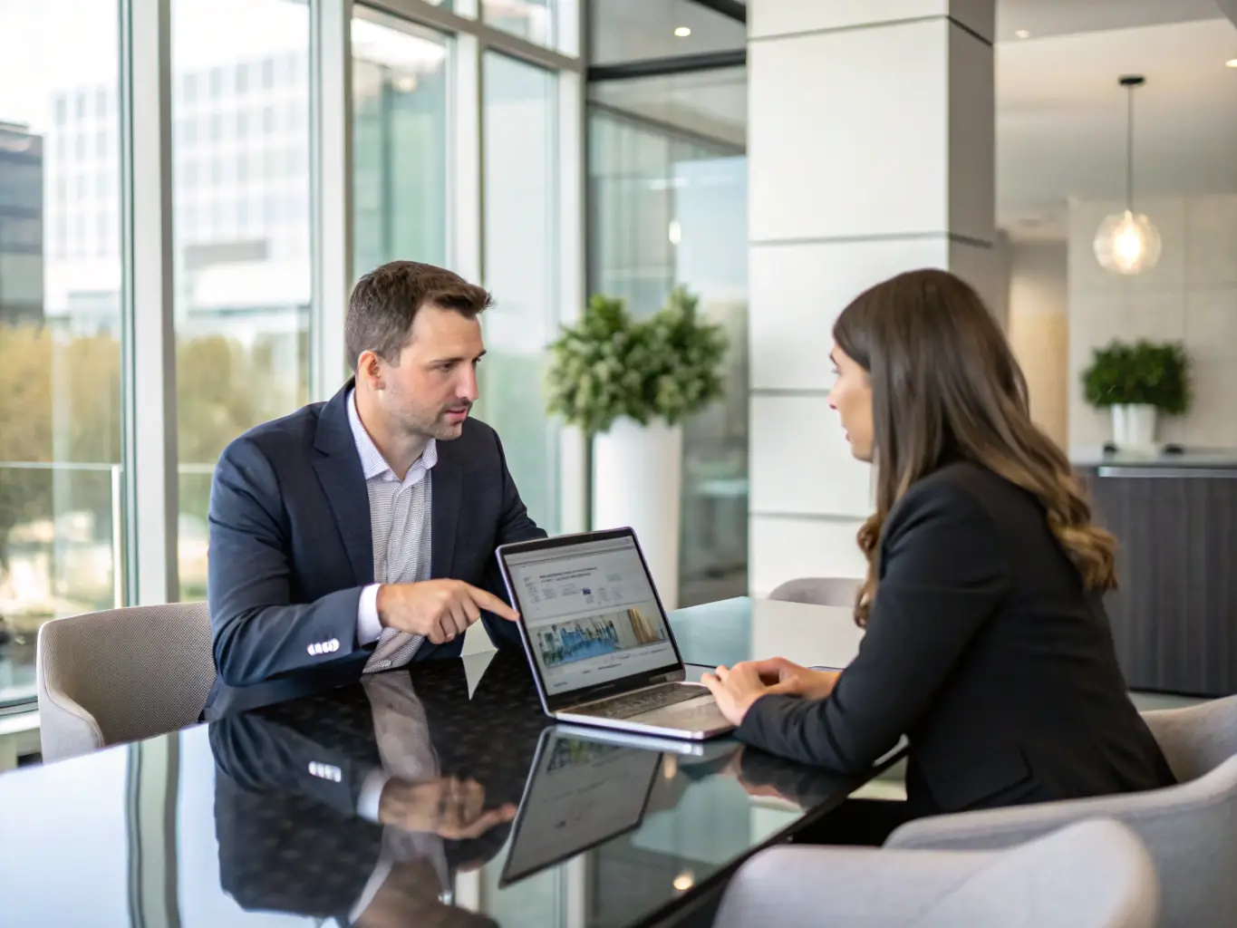 A consultant discussing growth strategies with a client at a table, with charts and a laptop in the background, symbolizing Wyndix GmbH's expertise in growth consulting.